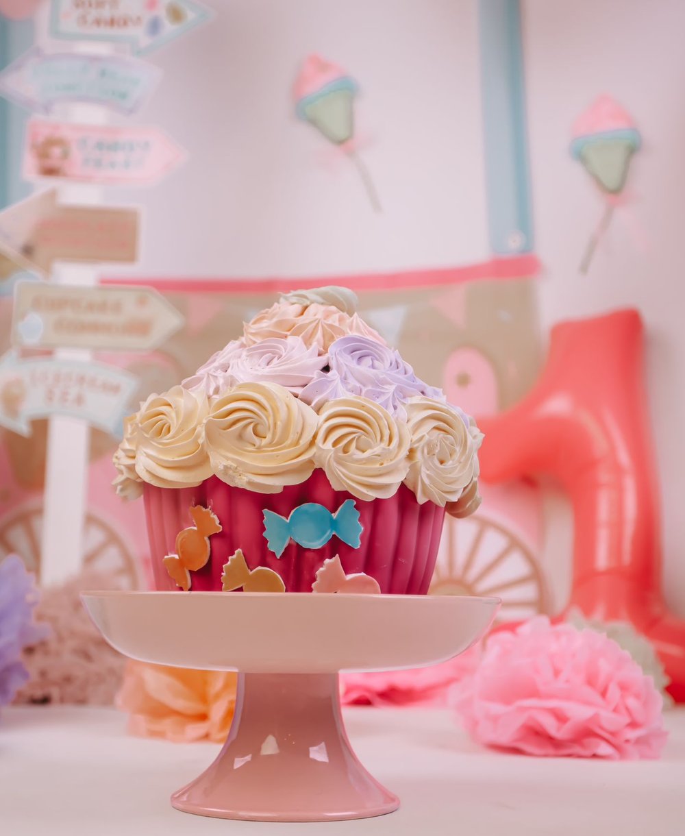 Grote roze cupcake-taart met bloemen en snoep decoratie